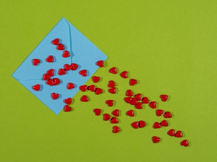 a blue envelope with red hearts coming out of it