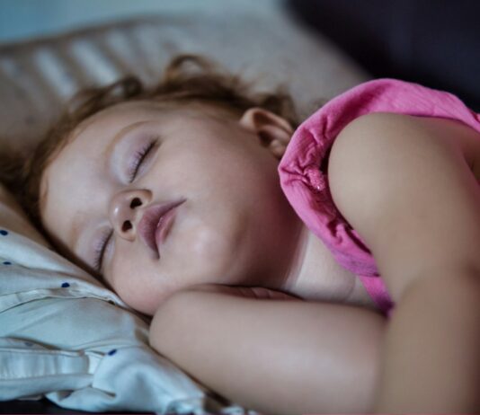 수면의 질이 건강을 결정한다…충분한 잠이 필요한 이유 a little girl sleeping on a bed with her eyes closed