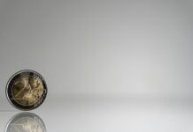 통장 잔고와 마음 건강의 상관관계, 재정적 웰니스 a close up of a coin on a reflective surface