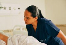 간병비 부담 완화된다… 내년부터 정책 변화 예고 A nurse is attending to a patient in a hospital.