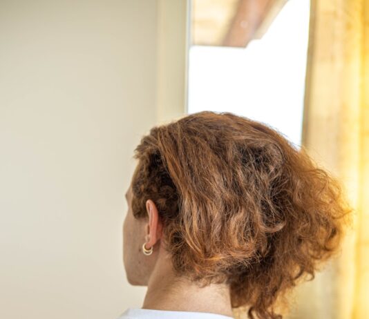 풍성하고 건강한 머릿결을 위한 5가지 헤어 관리법 a woman in a white shirt looking out a window