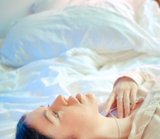 “아무리 자도 피곤해요”… 혹시 당신도 ‘수면 무호흡증’일 수 있습니다 woman in white shirt lying on bed