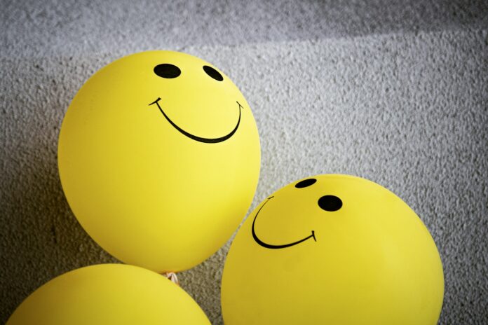 Photo by Tim Mossholder yellow smiley emoji on gray textile