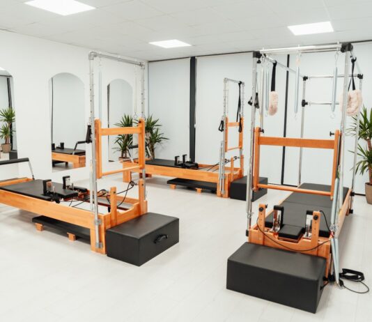 MZ세대와 시니어 모두 사로잡은 필라테스, 올해 건강 트렌드로 급부상 a gym with a row of machines and mirrors