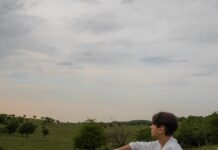 ‘만성피로’ 잡는 법, 최신 생활 트렌드가 바꾼 해법은? a man sitting on a blanket in the middle of a field