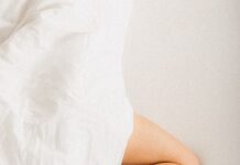 “하루 종일 앉아 있는 당신, 혈관 건강 괜찮나요?” a person laying in a bed with a white sheet