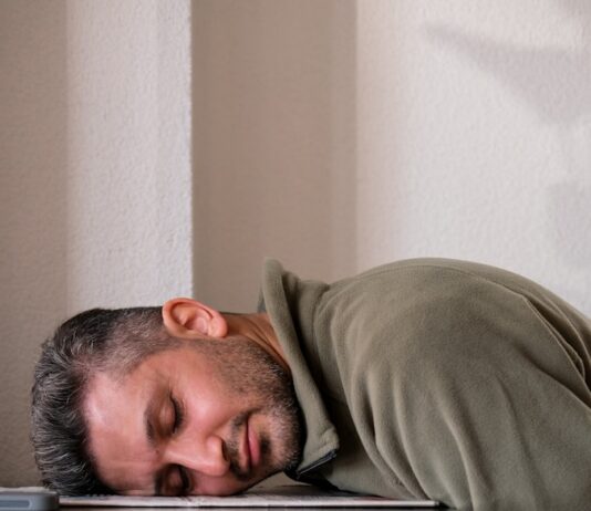 ‘만성피로’, 현대인의 일상을 위협하다… 원인부터 최신 관리법까지 A man is sleeping on the floor with his head on a laptop