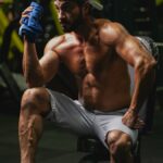 “근육 관리, 일상 속 작은 변화로 건강 챙기기” a shirtless man sitting on a bench in a gym