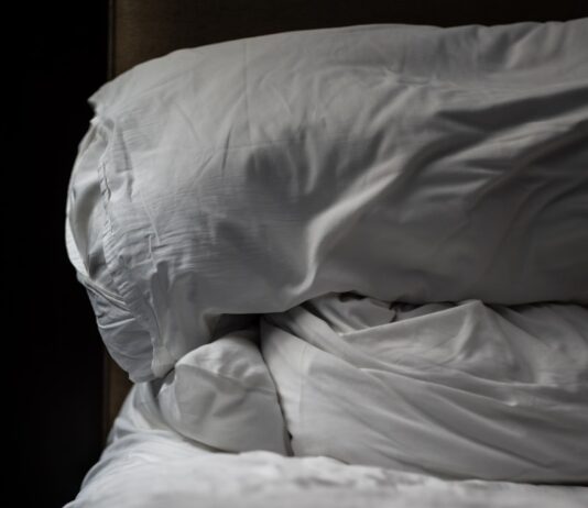 ‘슬리포노믹스’ 시대, 수면의 질이 성공의 열쇠로 떠오르다 a white pillow on a bed