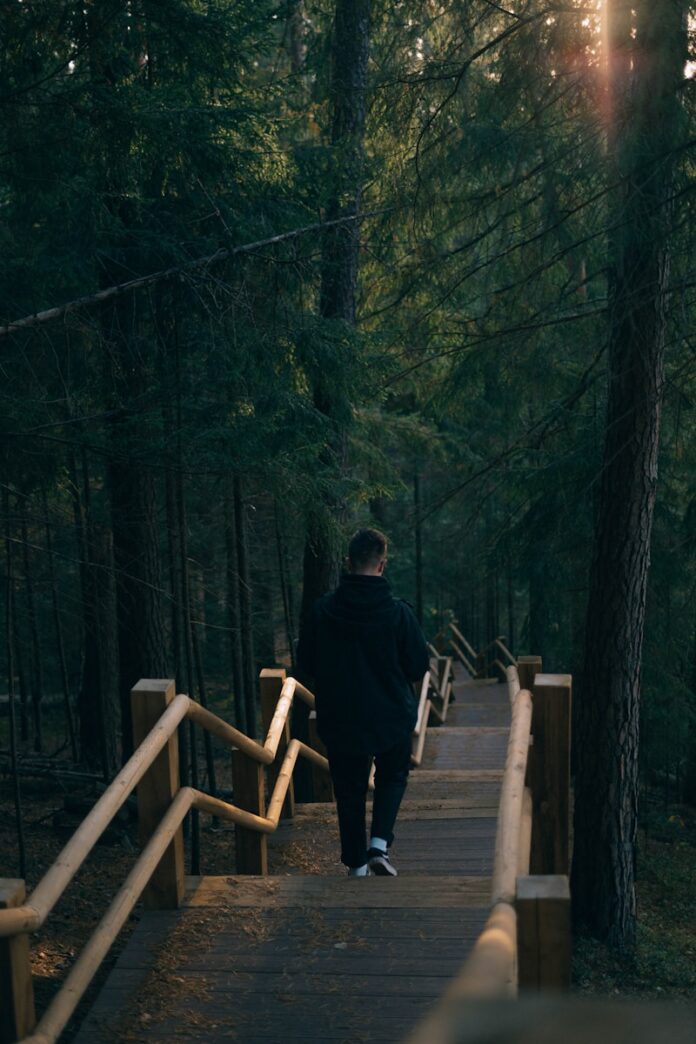 Photo by Ligita Kachanovska man walking near trees
