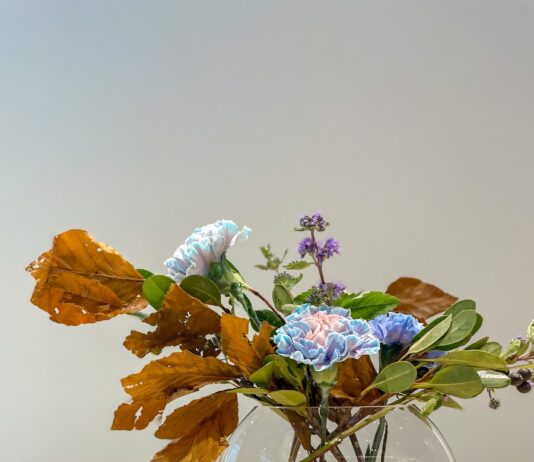 일상 속 작은 변화로 큰 효과, 스트레스 관리법 a glass vase filled with flowers on top of a wooden table