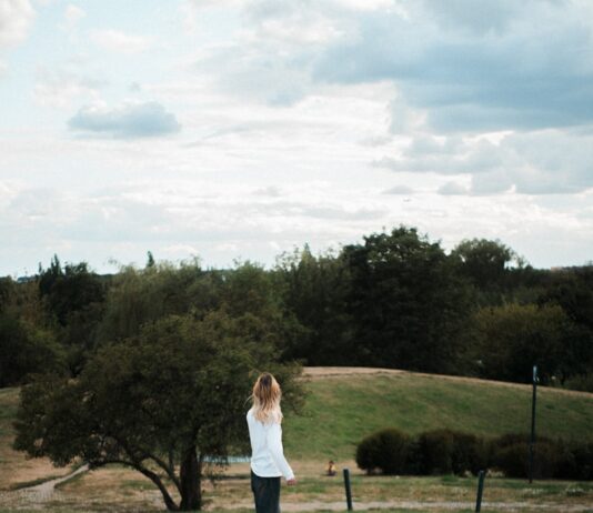 마음 건강도 챙기는 ‘마음 챙김 산책’, 일상 속 작지만 큰 변화 A person walks on a path in a grassy landscape.
