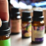 일상 속에 스며드는 대체요법, 간편하게 즐기는 건강 습관 a hand touching a bottle of essential oils