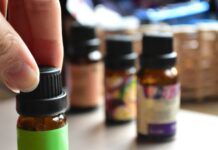 일상 속에 스며드는 대체요법, 간편하게 즐기는 건강 습관 a hand touching a bottle of essential oils