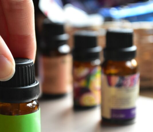 현대인의 일상 속 대체요법, 작지만 확실한 건강 루틴으로 인기 a hand touching a bottle of essential oils