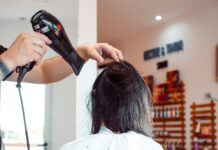 “건강한 헤어케어, 일상에서 시작하세요…지속가능한 뷰티 트렌드로 자리잡아” woman in white shirt holding hair blower