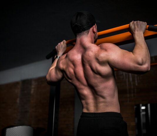 “근육”에 투자하는 시대…바쁜 일상 속 똑똑하게 실천하는 근육 생활습관 topless man in black shorts holding orange bar