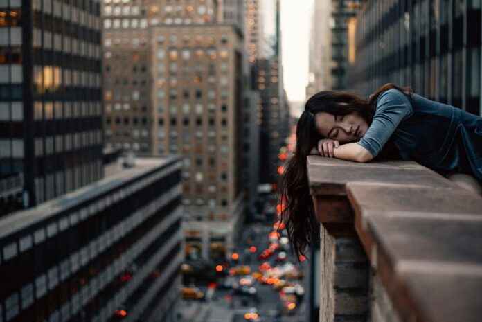 Photo by Hernan Sanchez woman leaning on top building rail during daytime