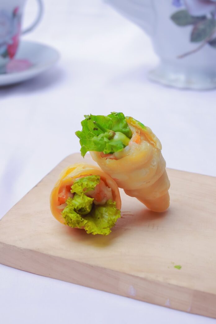 Photo by akhmad jazuli a wooden cutting board topped with a vegetable roll