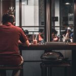독립생활·1인 가구 증가와 건강리스크: 혼밥, 편의식사, 외로움이 몸에 미치는 영향 man sitting on brown wooden bar stool beside backpack on wooden bar stool
