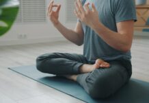 과도한 자기관리의 역설: 건강을 쫓을수록 멀어지는 이유 Man meditating in lotus pose on yoga mat.