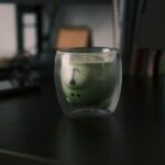 “직장인 건강, 작은 습관이 만든다… 최신 트렌드와 실천 팁” a glass filled with liquid sitting on top of a desk