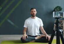 필라테스, 일상 속 건강한 움직임으로 자리잡다 Man meditating on yoga mat recording with phone.