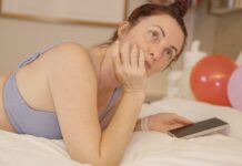 디지털 기기와의 관계 재설정: ‘스크린 디톡스’의 심리·신체 영향 Woman lying on bed with phone and balloons