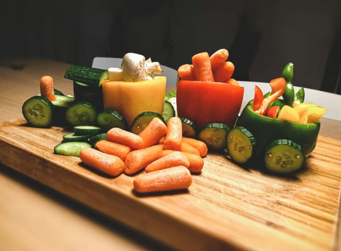 Photo by Sigmund sliced carrots and green bell pepper on brown wooden chopping board
