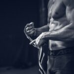 근육, 건강 관리의 새로운 키워드… 일상 속 실천법은? a shirtless man holding a pair of gloves