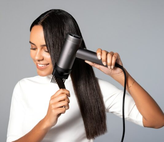 집에서도 건강한 두피와 머릿결…최근 떠오르는 ‘마이크로 관리’ 트렌드 a woman blow drying her hair with a hair dryer