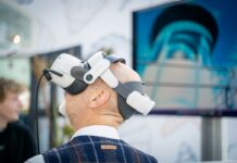 운동의 패러다임이 바뀐다 – ‘양’보다 ‘질’, ‘강도’보다 ‘타이밍’ A man wearing a robot headpiece in front of a TV