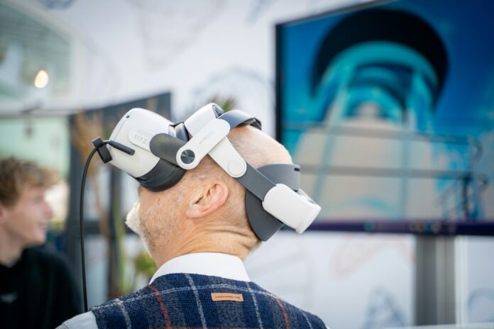 A man wearing a robot headpiece in front of a TV