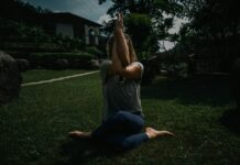 디톡스 요가: 비틀기 동작으로 체내 독소를 제거하는 ‘장 청소’ 가이드 a woman sitting on the ground with her hands in the air