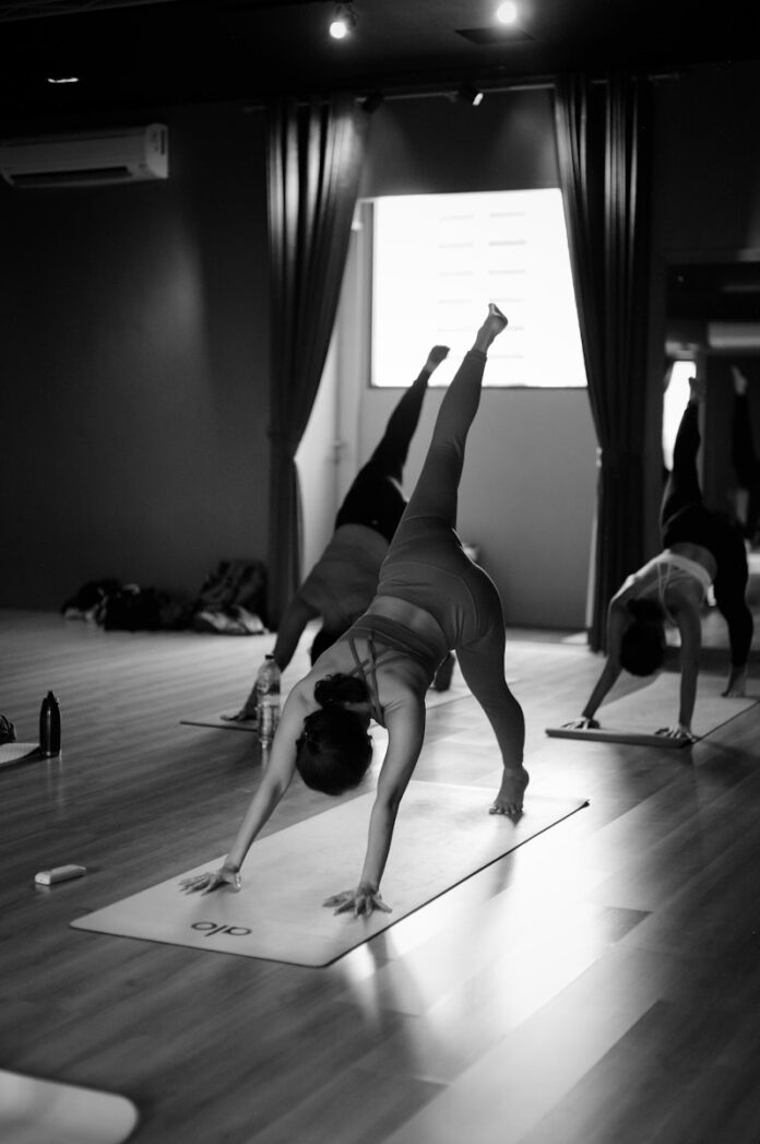 Photo by Rendy Novantino a group of people doing yoga in a room