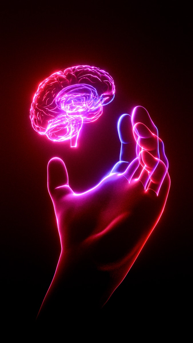 Photo by TSD Studio A person's hand holding a glowing brain model