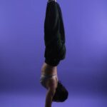 바쁜 일상 속 ‘필라테스’, 내 몸을 위한 작은 변화 a person doing a handstand on a purple background