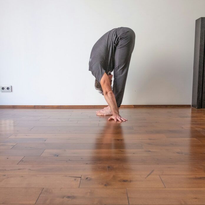 a man doing a handstand on a hard wood floor