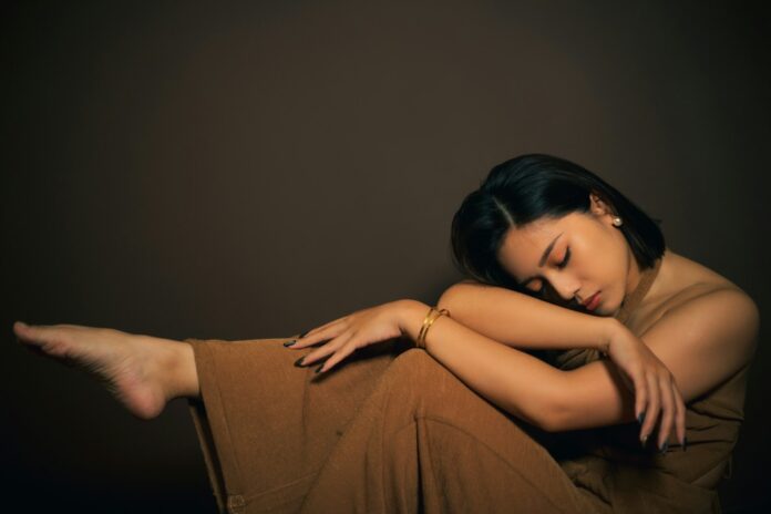 a woman sitting on the ground with her arms crossed