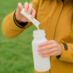 “내 몸에 맞는 영양, 일상 속 똑똑하게 챙기기” Person pouring powder into a water bottle