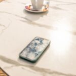 “소소하지만 확실한 변화, 스트레스 관리의 새로운 루틴” Smartphone and coffee cup on marble table