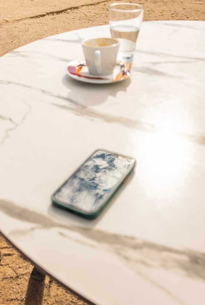 Photo by Alexandros Giannakakis Smartphone and coffee cup on marble table