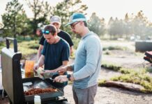바쁜 일상 속 ‘마음 챙김 식사’ 실천법…행복한 식탁 만드는 작은 습관들 Three men cooking food on an outdoor grill.