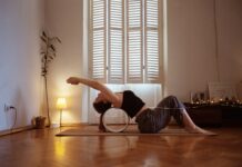 우아함의 완성, 데콜테 라인 : 승모근을 잠재우는 섬세한 설계 A woman is doing a yoga pose on a mat