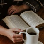 건강한 수면 습관, 꾸준한 실천이 핵심…작은 변화로 큰 효과 A person sitting on the floor with a book and a cup of coffee