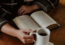 건강한 수면 습관, 꾸준한 실천이 핵심…작은 변화로 큰 효과 A person sitting on the floor with a book and a cup of coffee