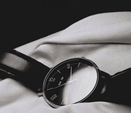 “만성피로, 일상 속 작은 변화로 극복하세요” a watch sitting on top of a white sheet