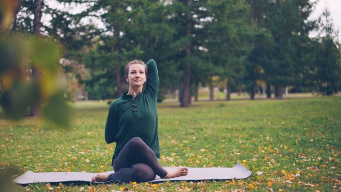 Photo by Vitaly Gariev Woman practicing yoga on mat in park
