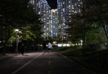 ‘마음챙김 걷기’, 일상 속 활력 더하는 새로운 건강 습관 People jogging on a path at night near apartments.