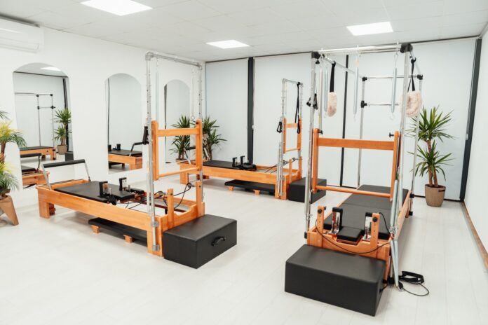 a gym with a row of machines and mirrors